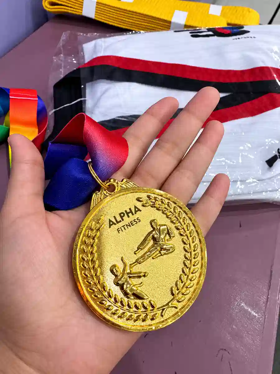 Alpha Fitness gold martial arts medal close-up